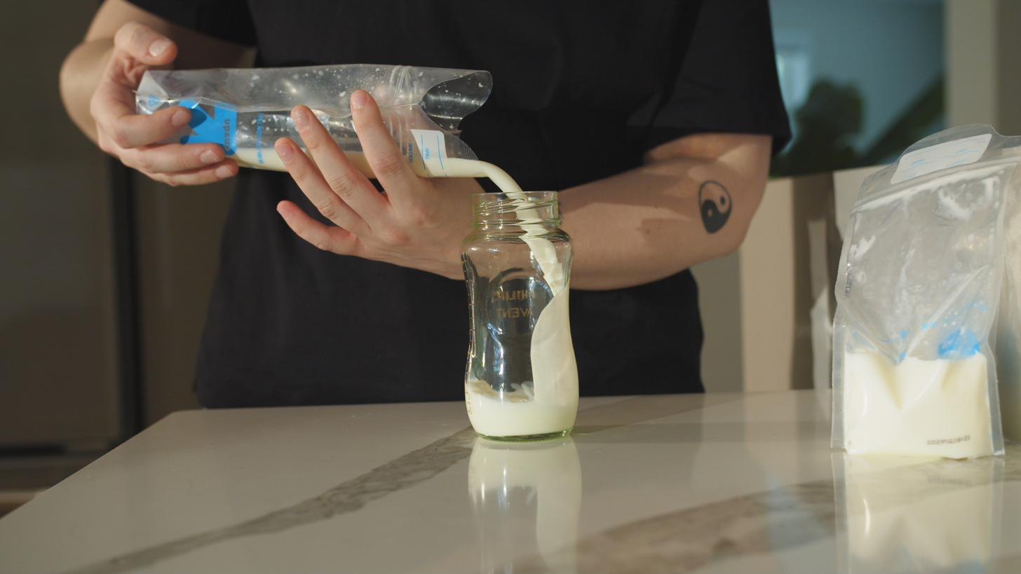 Pouring thawed breast milk from the bag into a bottle