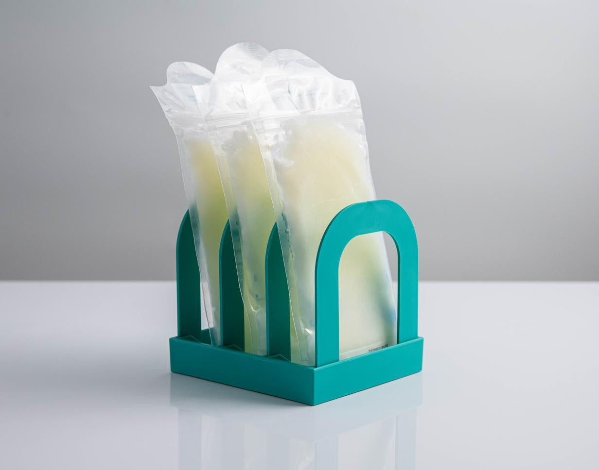 Mylk Mate holding three frozen breast milk bags upright