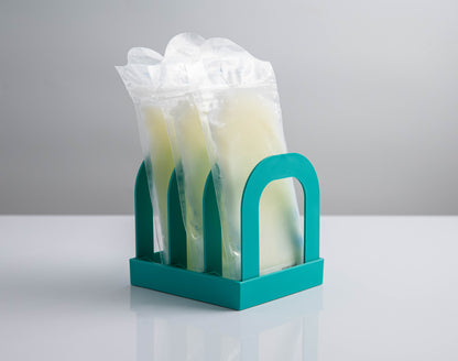 Front view of Mylk Mate holding three frozen breast milk bags upright in its three slots